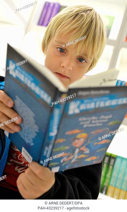 Nine-year old Silas from Mainz thumbs through a book for young people at the Frankfurt Book Fair in Frankfurt Main,  Germany, 09 October 2013
