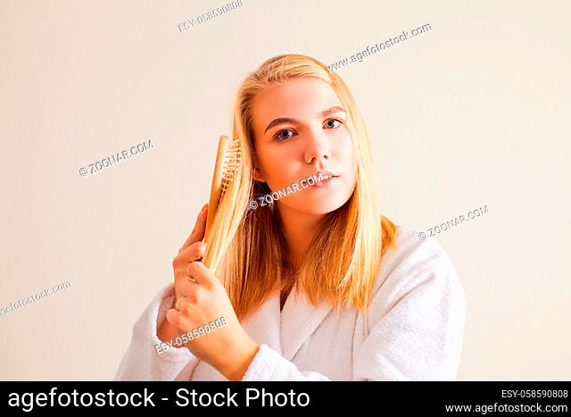 Hair care conept. Woman applying ptotection remedy for blonde hair. Hair treatment, cosmetics and wellness