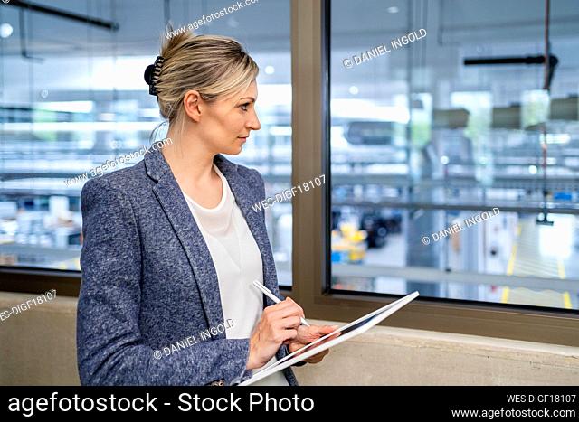 Businesswoman using digital tablet in factory office