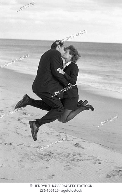Businesspeople kissing on beach