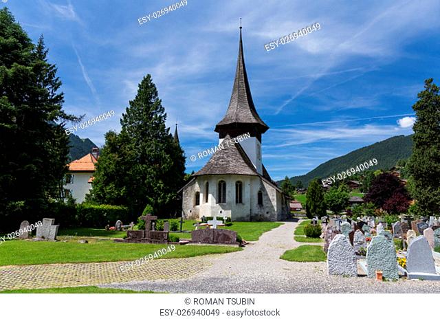 Church with wooden roof and cemetery in Rougemont Vaud canton of Switzerland