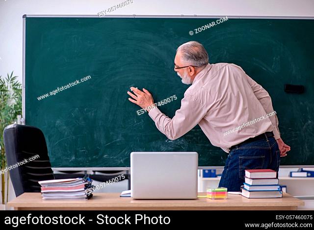 Senior male teacher sitting in the classroom