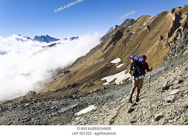 Man hiking, ascent to Col Lauson, Crete du Tuf, Gran Paradiso National Park, Aosta valley, Italy