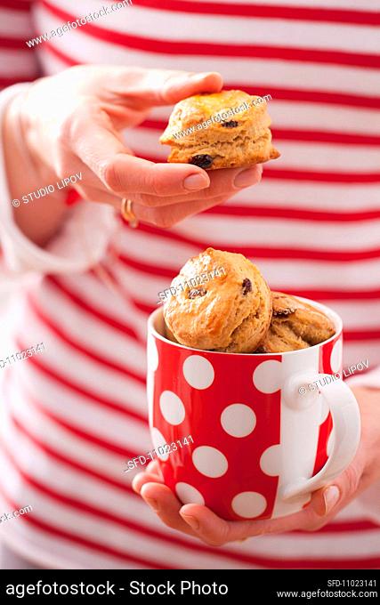 Lady holding a cup with saffron scones