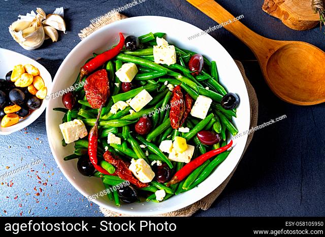Spicy green bean salad with olives, feta cheese and dried tomatoes