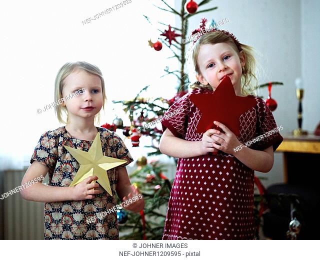 Two girls decorating christmas tree