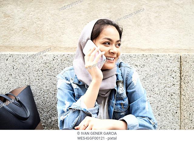 Young woman wearing hijab on cell phone