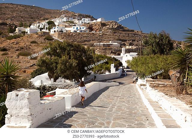 Girl walking on the road leading from the Kastro-Castle area to the old town Chora or Chorio, Sikinos, Cyclades Islands, Greek Islands, Greece, Europe