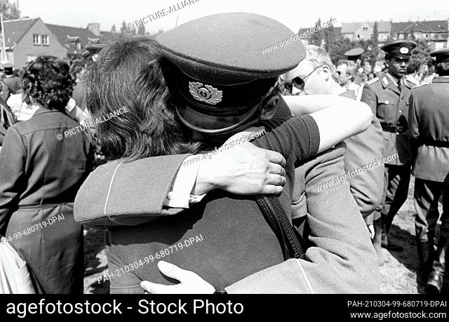 15 March 1982, Saxony, Delitzsch: Embrace with wife. Young soldiers of the NVA are sworn in on a sports field in Delitzsch in spring 1982