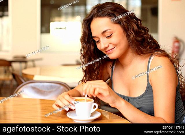 Casual woman stirring coffee in a restaurant