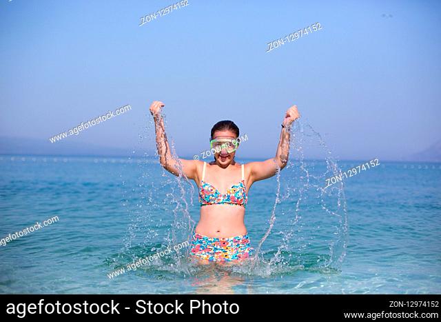 Portrait of smiling girl in swimming mask against the sea and sky