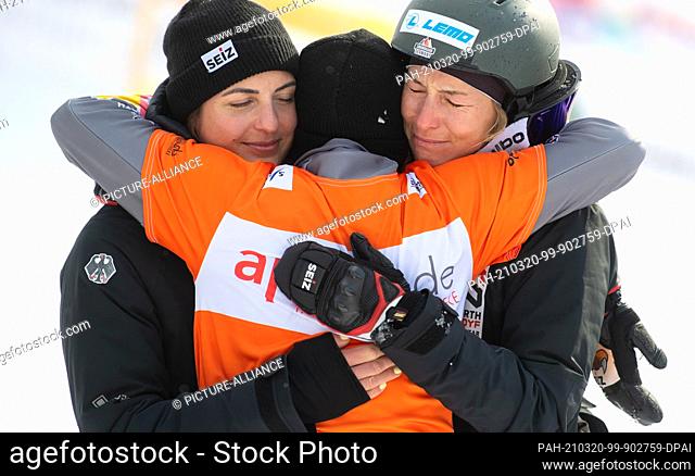 20 March 2021, Bavaria, Berchtesgaden: Snowboard: World Cup, Parallel Slalom, Women, Ramona Theresia Hofmeister (M) from Germany hugs Selina Jörg (r) and...