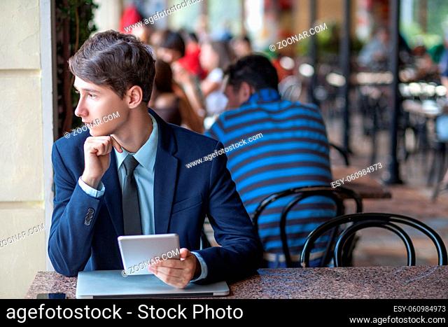young man in business suit sitting in office and working