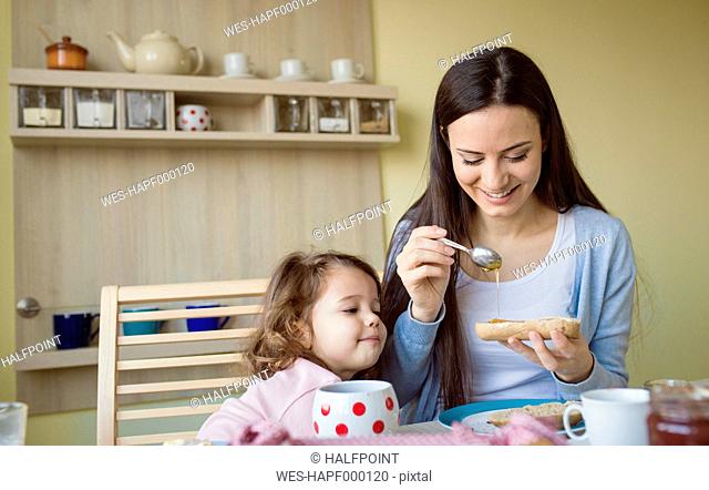 Mother and her little daughter together at breakfast table