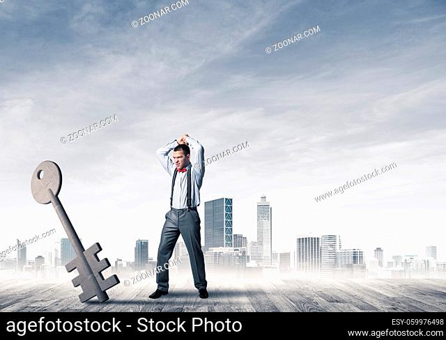 Determined businessman against modern cityscape breaking with hands stone key figure