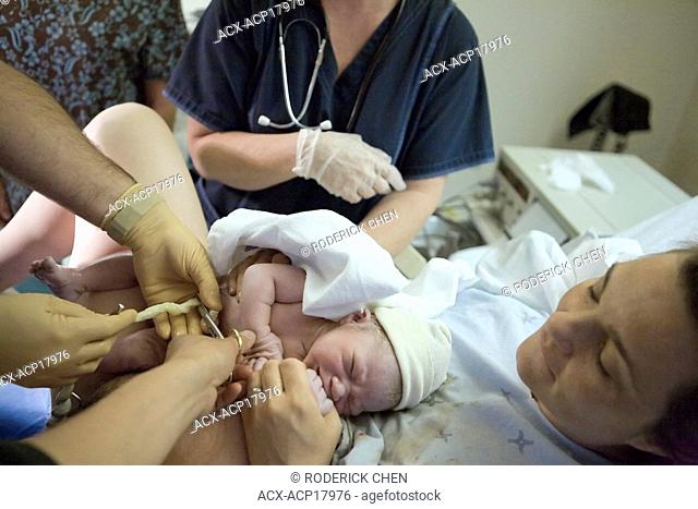 36 year old woman with her newborn as umbilical cord is cut, Chateauguay, Quebec, Canada