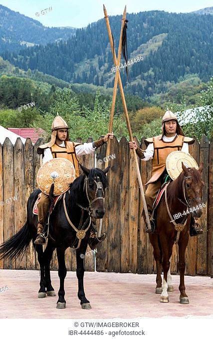 Two men on horseback in front of the entrance to the Kazakh ethnographic village aul Gunny, Talgar, Almaty, Kazakhstan