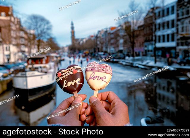 love romantic ice cream with on the background people ice skating at the frozen canals of Amsterdam, Valentine Romantic concept. Amsterdam Netherlands