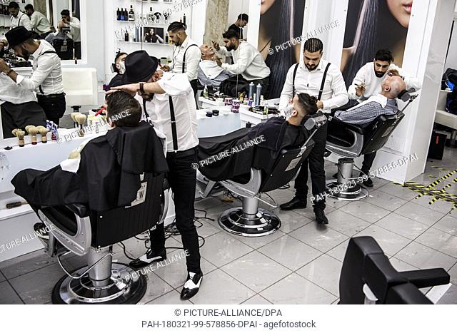 31 January 2018, Germany, Berlin: Barbers Sebastiano (left to right), Onay Temel and Kubilay working in the barber shop. Photo: Christophe Gateau/dpa