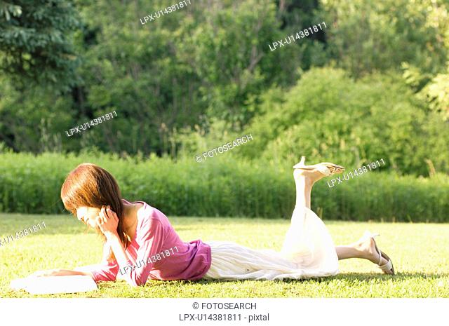 Woman reading a book in a field