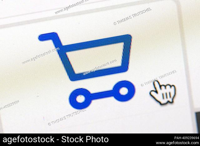 Symbolic photo on the subject of online shopping. The symbol of a shopping cart and a mouse pointer can be seen on a computer display