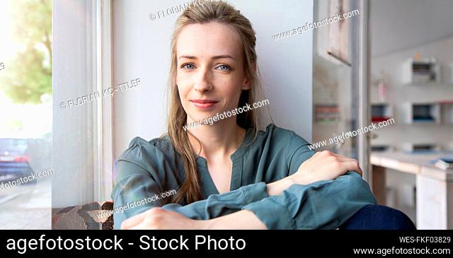 Portrait of confident woman at the window at home