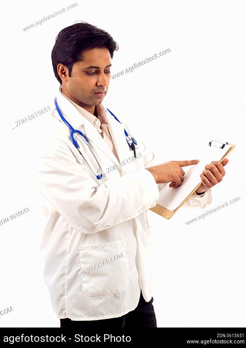 Young Asian medical doctor pointing at blank clipboard ad space isolated over white background