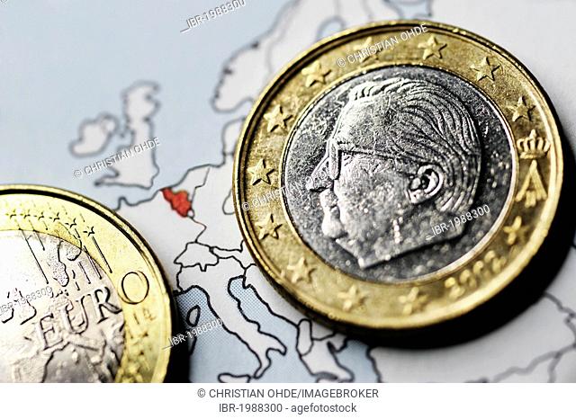 Belgian one-euro coin on a map, symbolic image for the debt crisis in Belgium