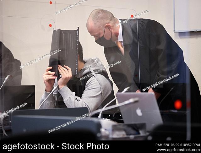 06 January 2022, Hamburg: Thomas Penneke (r), lawyer, talks to his client before the start of the trial in the courtroom in the Criminal Justice Building
