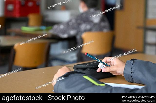30 August 2021, Baden-Wuerttemberg, Sindelfingen: A pupil works on a worksheet in German at the learning bridge at the Realschule am Goldberg before the regular...