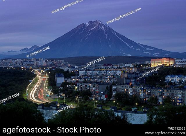 Summer cityscape of Kamchatka Peninsula: night view of urban development of Petropavlovsk-Kamchatsky City, driving automobiles on city asphalt road on...