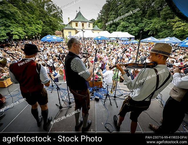 16 July 2023, Bavaria, Munich: Musicians play for the dancers at the Kocherl Ball at the Chinese Tower. The traditional open-air folk dance festival at sunrise...