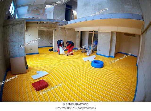 group of workera installing underfloor heating and colling in modern home