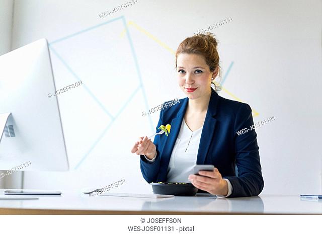 Businesswoman eating lunch in office