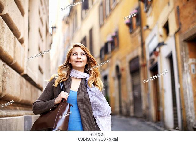 Young woman strolling down street, Rome, Italy
