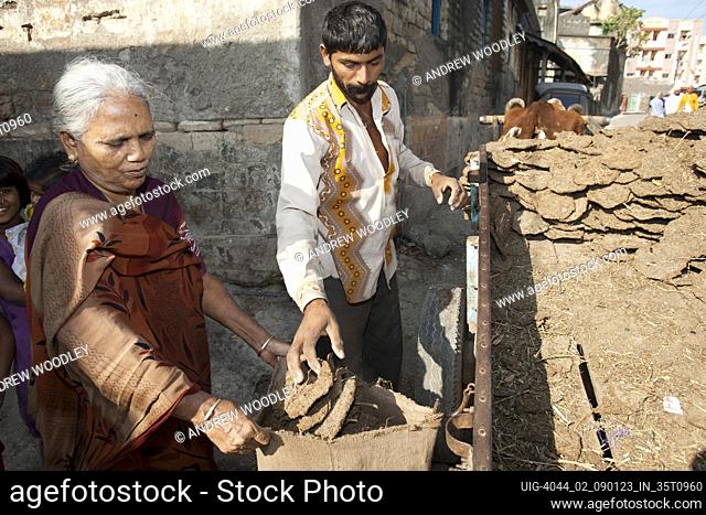 Elderly women buying cow dung fuel Junagadh Gujarat India