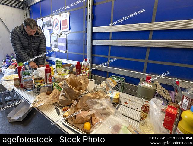 19 April 2023, Hesse, Gräfenhausen: A truck driver prepares his lunch in a makeshift kitchen. The drivers, who come from Eastern Europe