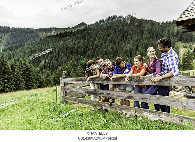 Group of friends leaning on wooden fence, Tirol, Austria