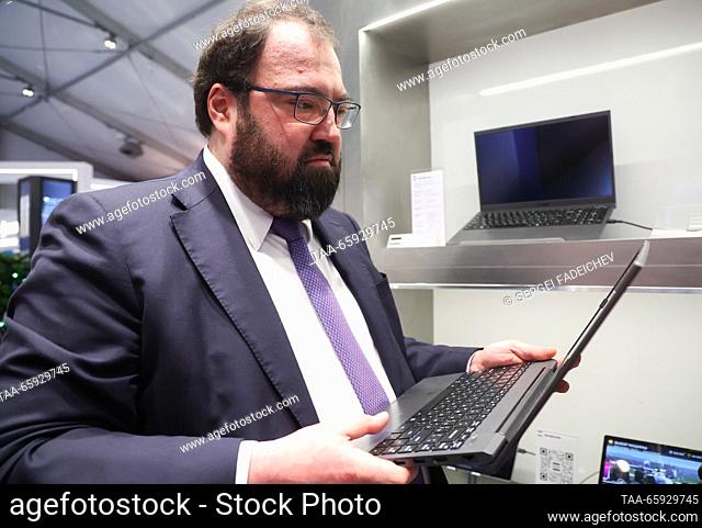 RUSSIA, MOSCOW - DECEMBER 20, 2023: Russia's Digital Development, Communications and Mass Media Minister Maksut Shadayev holds a Kvadra NAU LE14U laptop during...