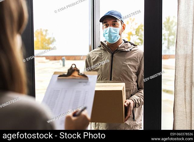 delivery man in mask with box and customer at home
