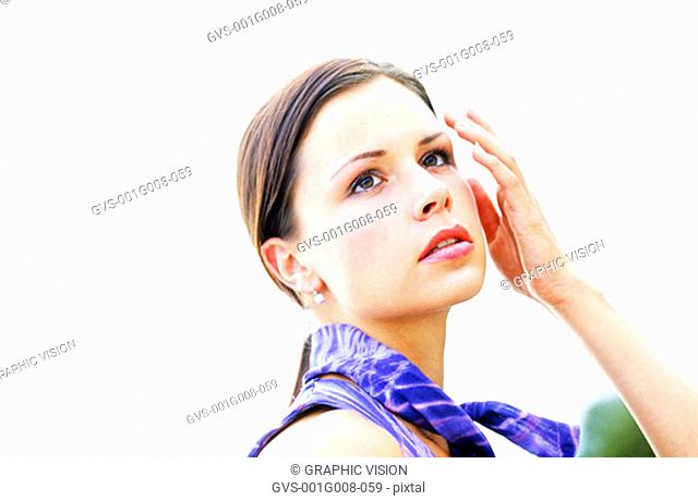 Young woman touching her face