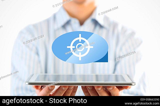 Businessman holding tablet with goal icon on screen