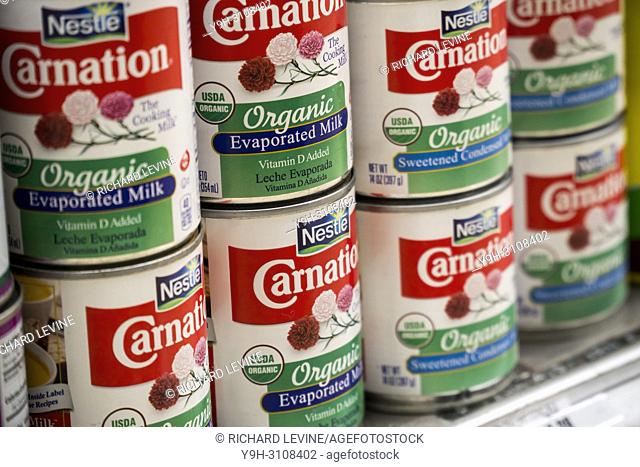 Cans of Nestle Foods products, Carnation Evaporated Milk and Carnation Sweetened Condensed Milk, both organic, are seen on a supermarket shelf in New York on...