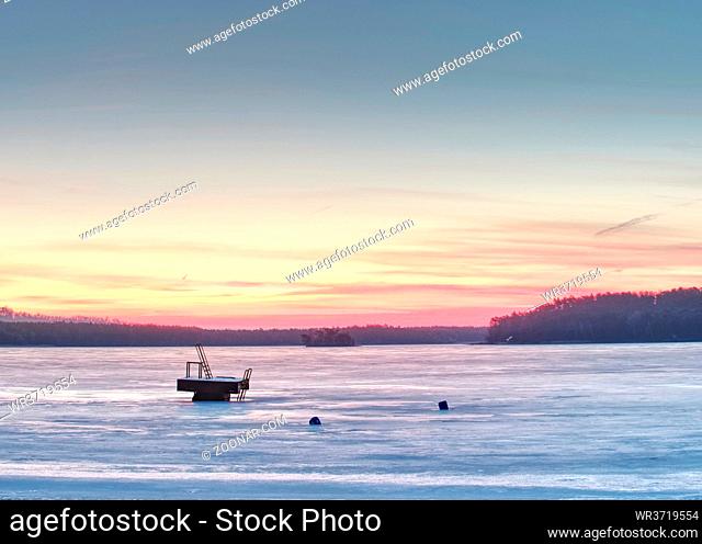 Frozen ice surface on lake with sunset backdrop. Aerial pattern on the frozen lake. Frozen lake ice captured with footprints
