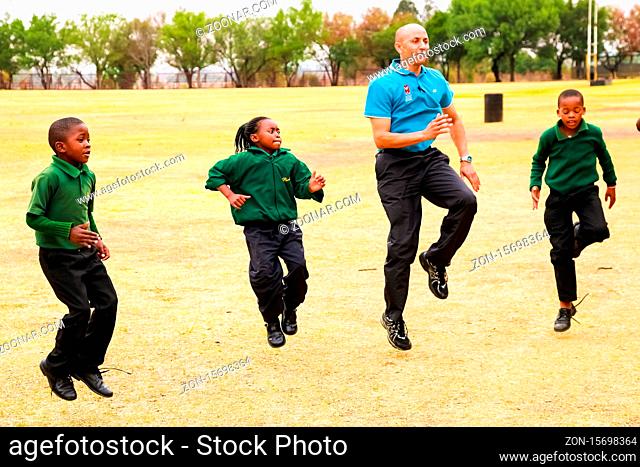 Johannesburg, South Africa - October 14 2010: Diverse African Primary School children doing physical exercise PT lesson