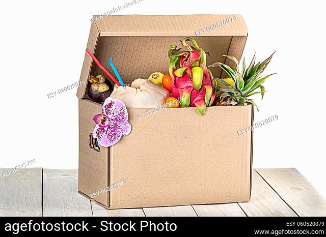 Tropical fruits in cardboard box isolated on white background