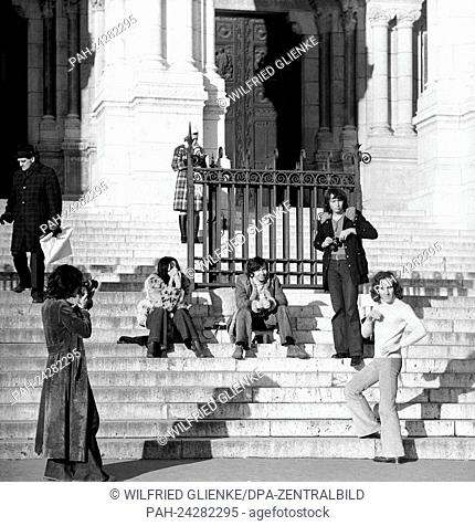Tourists take photographs of themselves on the stairs of the basilica Sacre Coeur de Montmartre in Paris, France, in November 1970