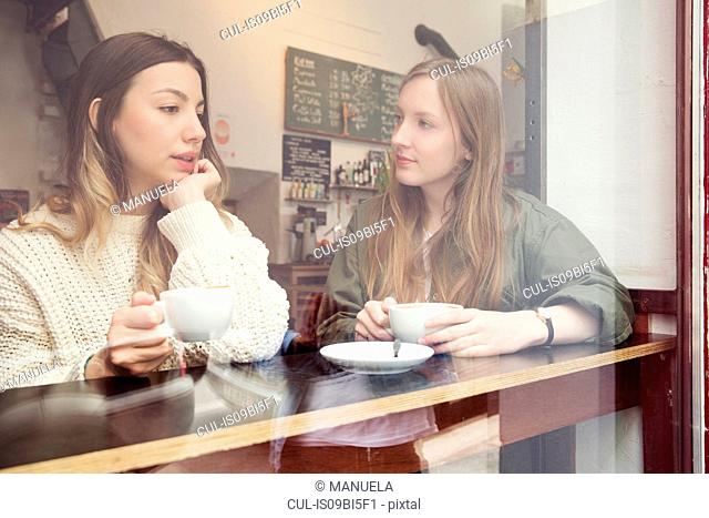 Young women chatting over coffee in cafe