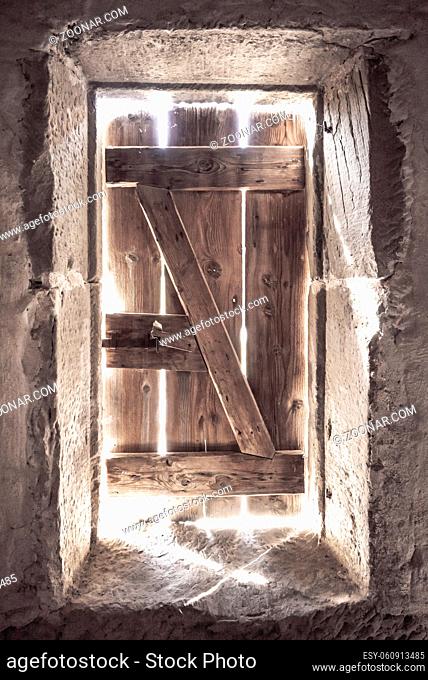 Strong light coming through the cracks from an old wooden door