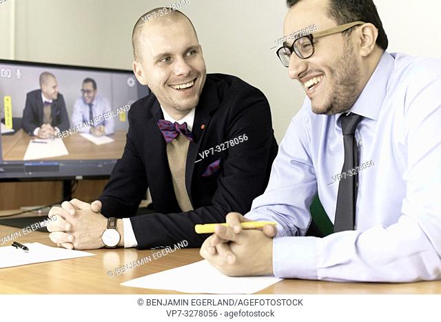 laughing business men at conference, lawyers consulting at online live stream, in office, in Cottbus, Brandenburg, Germany